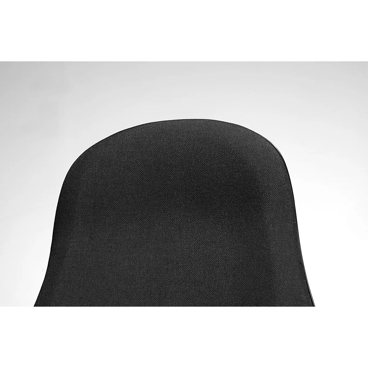 Close-up of the backrest of a black fabric chair against a light background.