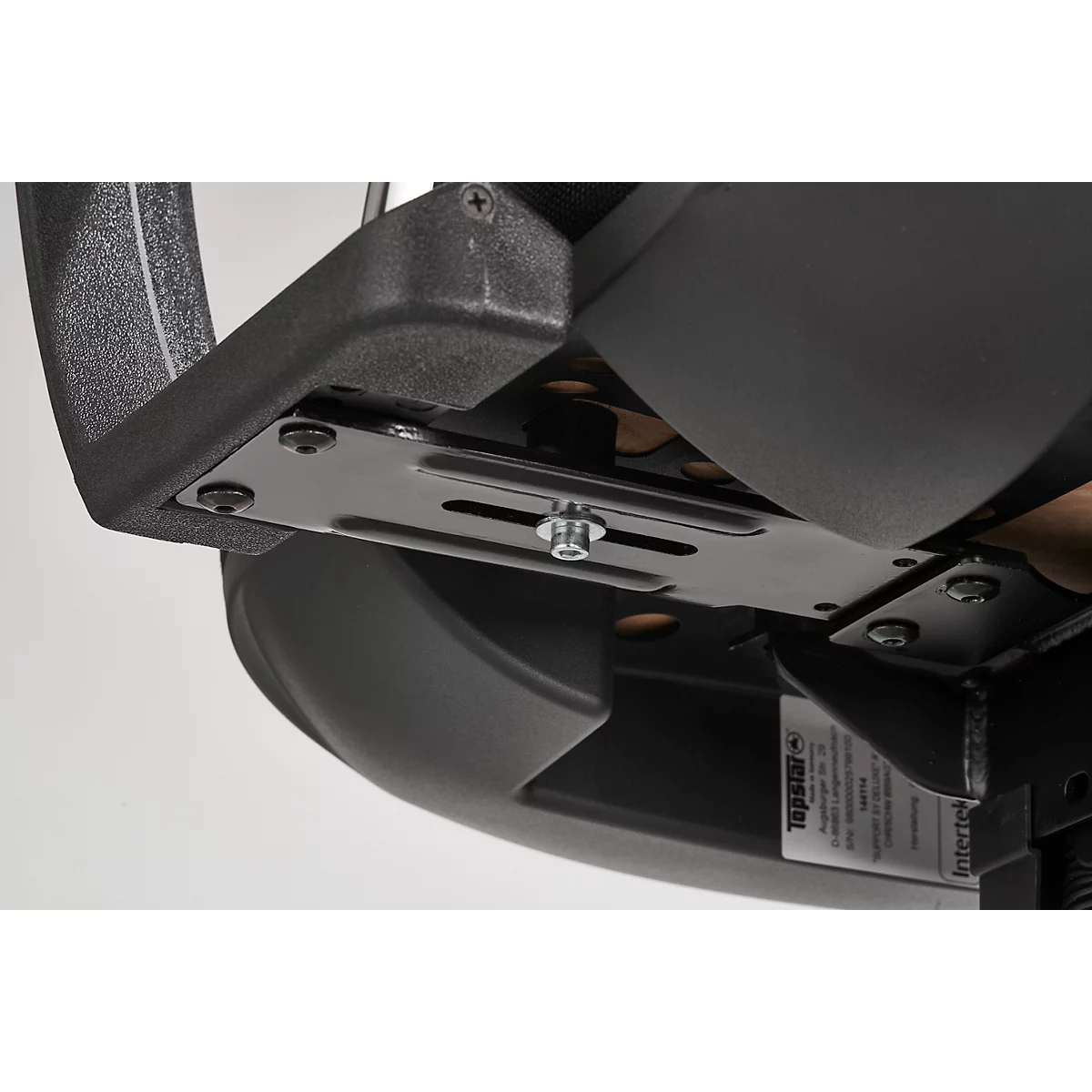 Close-up of the seat attachment of an office chair. Black metal plate with screws and nuts.