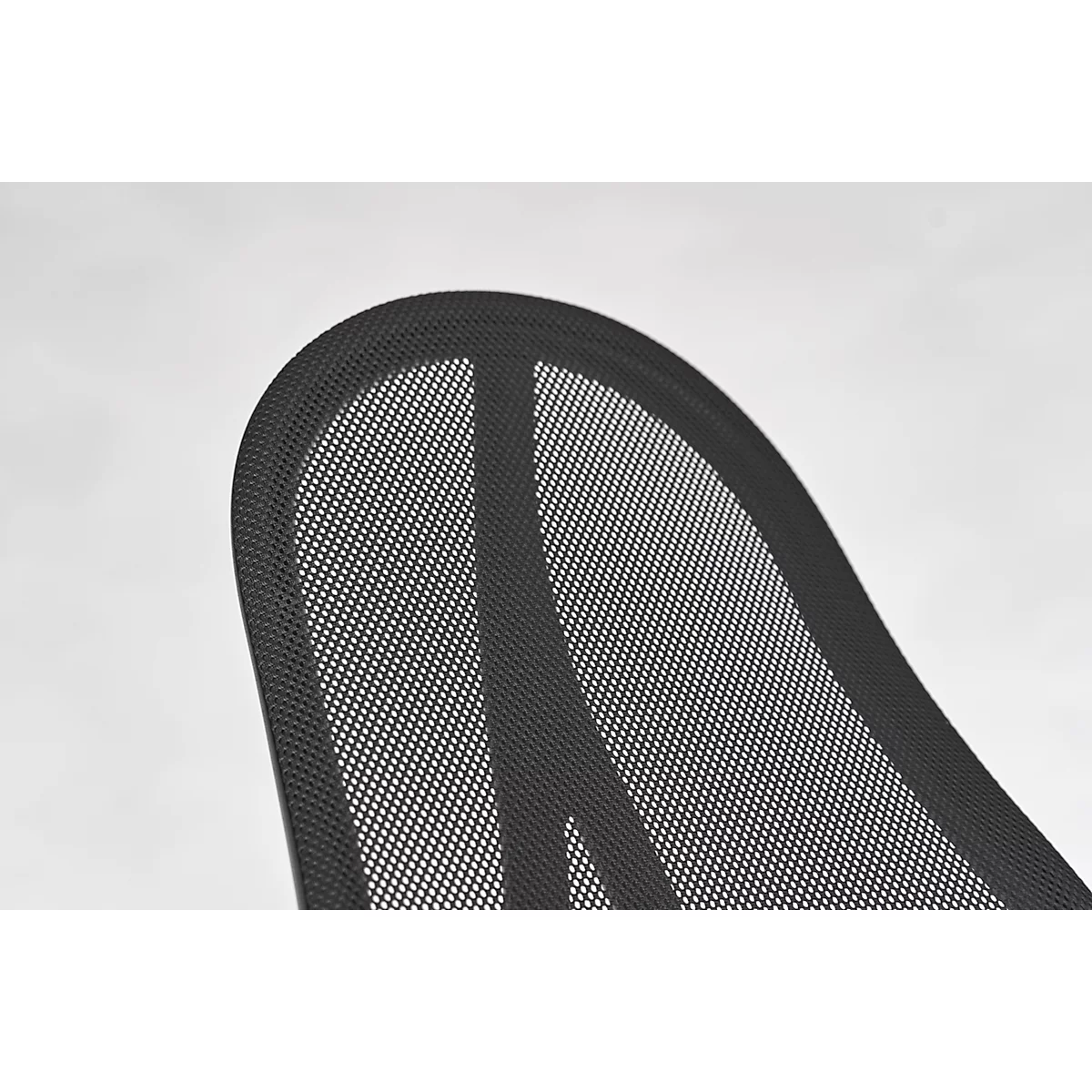 Close-up of a chair back made of black mesh with rounded edges.