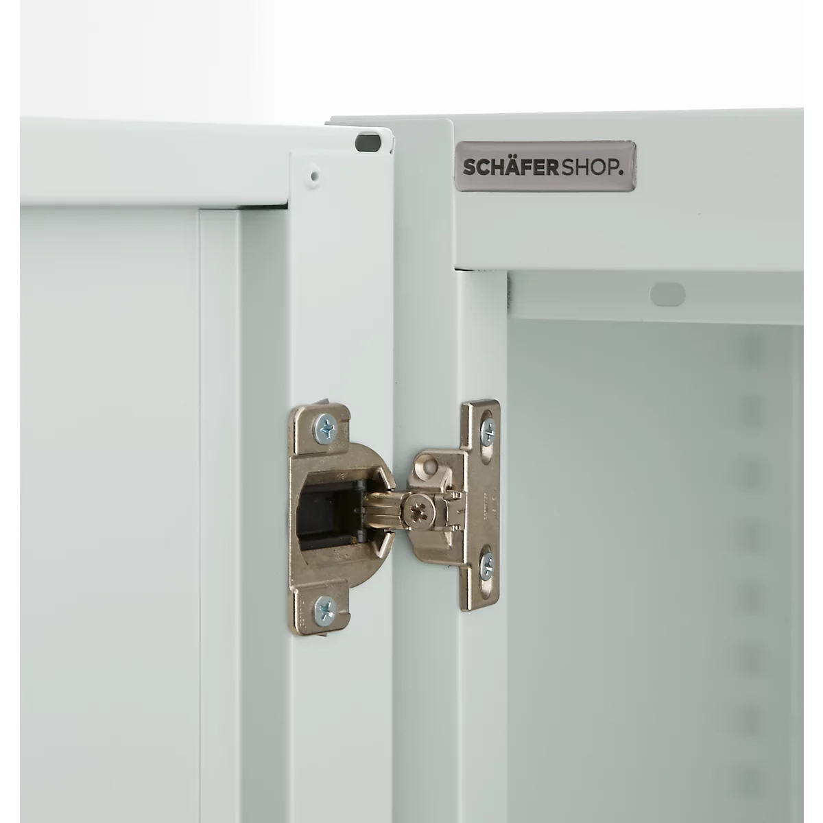 Close-up of a white cabinet with silver hinge. The logo "SCHÄFERSHOP" is visible.