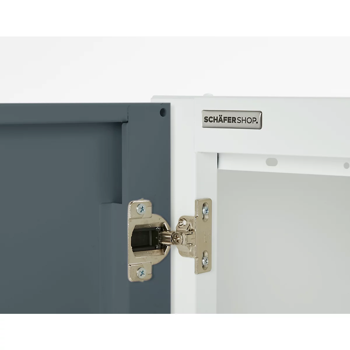 Detail shot of a cabinet door with hinge. Blue door on the left, white door on the right. The hinge is silver.