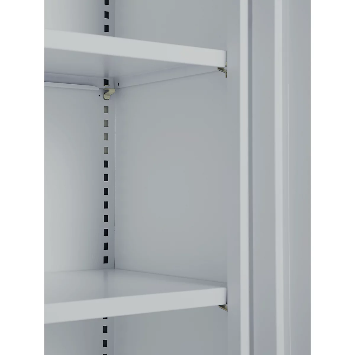 Inside view of a cabinet with two shelves, light grey. Rows of holes are visible on the sides.