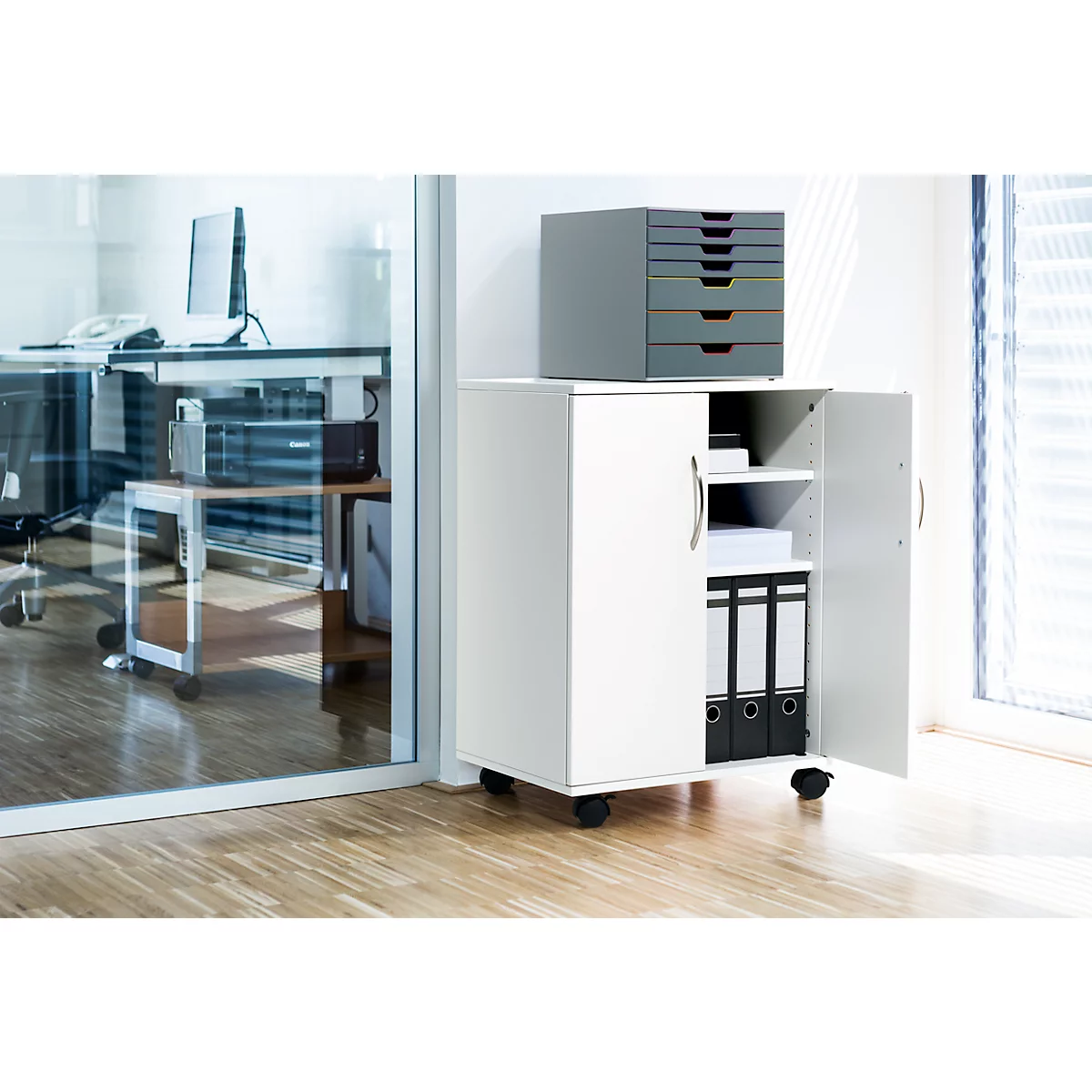 White mobile file cabinet with open doors. Folders and storage compartments are visible. On top a gray drawer box.