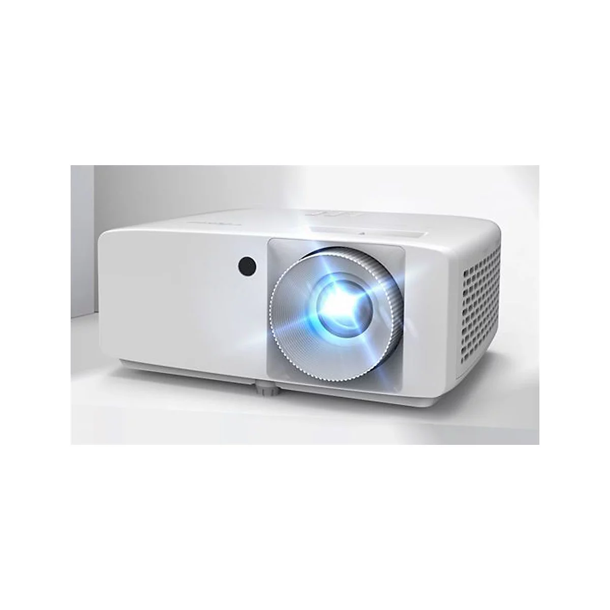 Projecteur blanc avec une lumière bleue vive. Il y a un bouton noir sur la gauche. Le projecteur est sur une surface blanche.