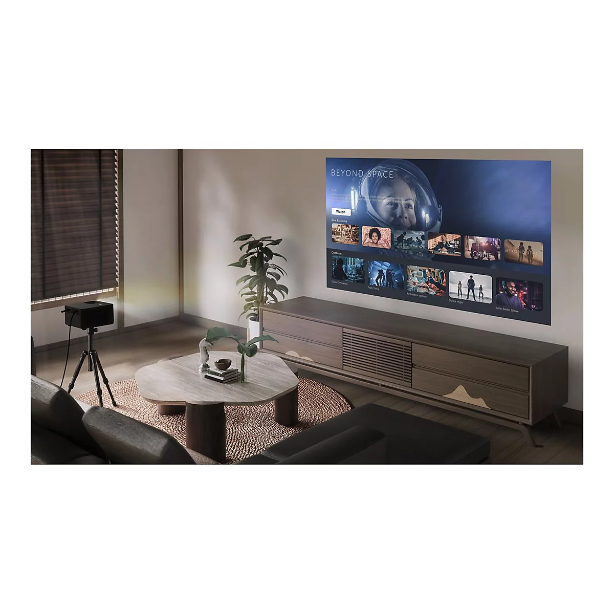 Une salle de cinéma à domicile avec un projecteur projetant un menu de films sur un mur. Canapé, table et armoire.