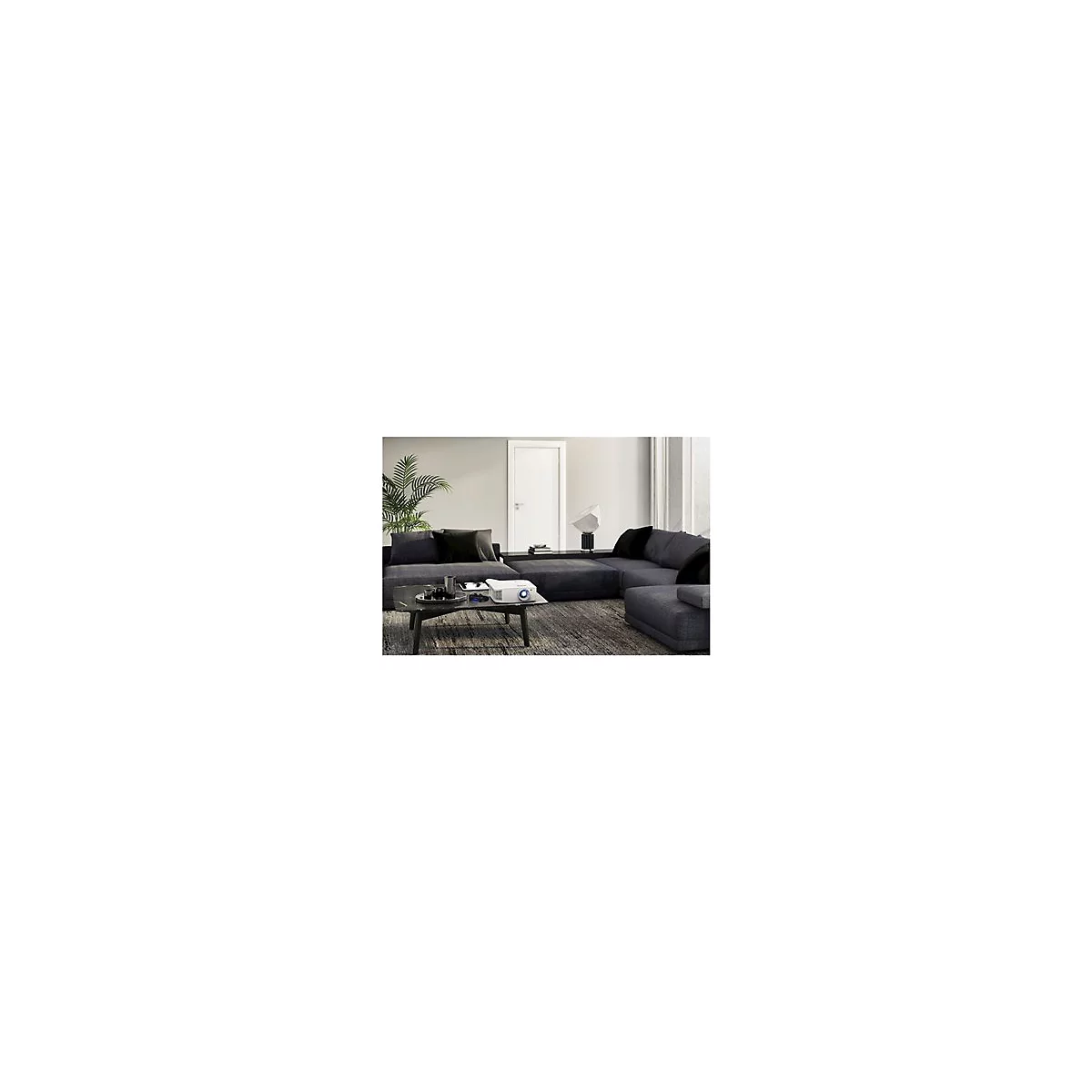 Ein weiÃŸer Projektor auf einem Couchtisch in einem Wohnzimmer mit Eckcouch, Pflanze und Lampe.