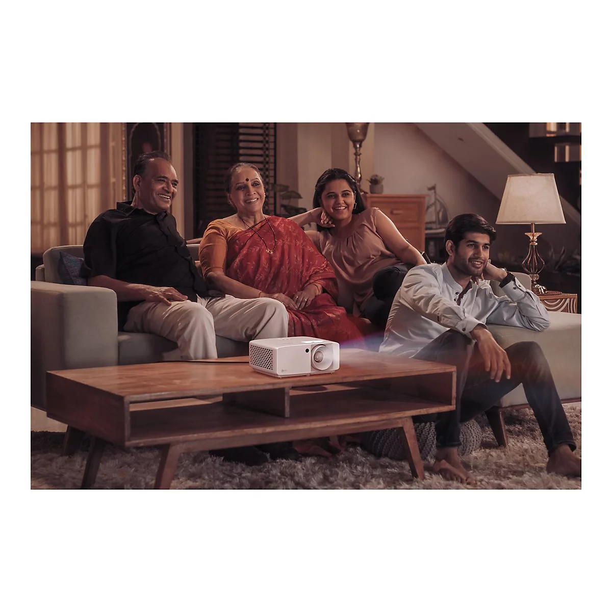 Une famille regarde un film ensemble. Un projecteur projette une image sur un écran invisible.