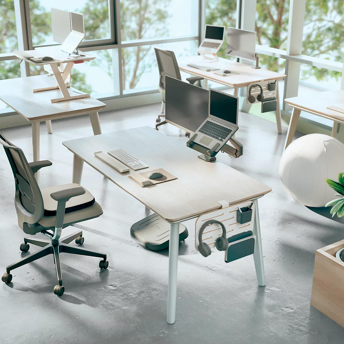 Bureau avec plusieurs bureaux, chaises et ordinateurs portables. Fenêtres en arrière-plan.
