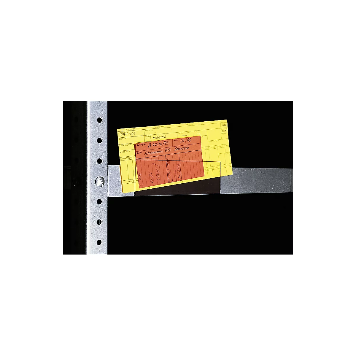 Yellow and red paper with handwritten notes lies on a gray metal construction.
