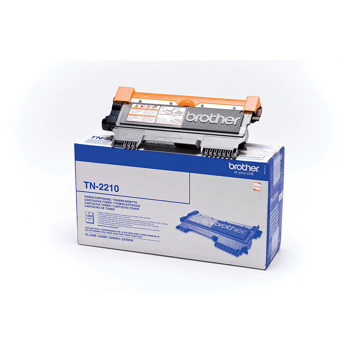 A Brother TN-2210 toner cartridge rests on its packaging. The cartridge is orange and black, the packaging white and blue.