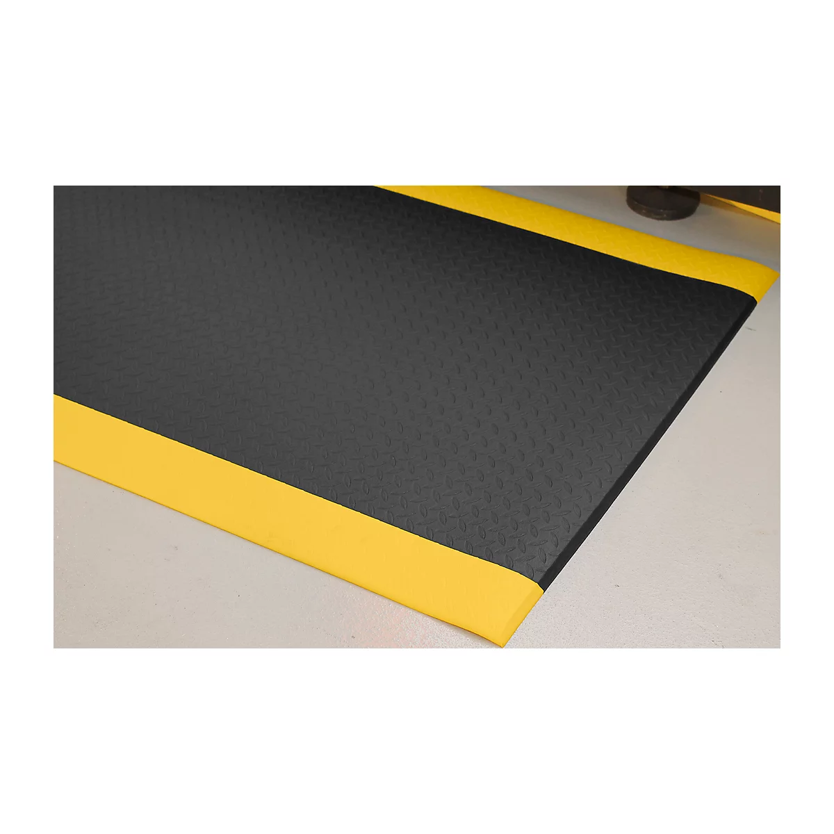 Black mat with yellow edges on a light surface.
