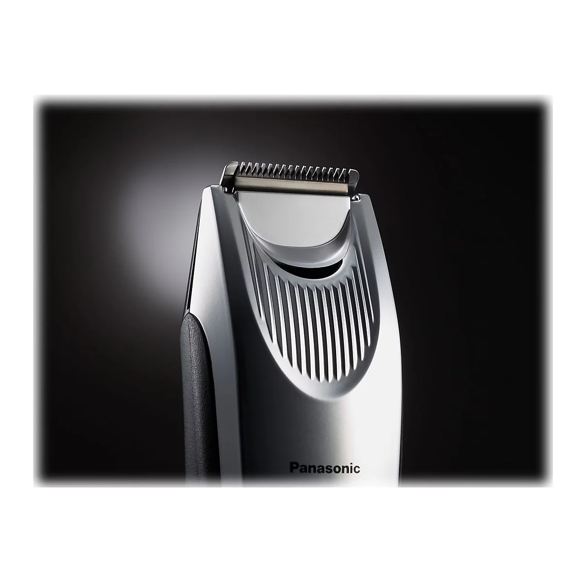 Gros plan sur une tondeuse à barbe Panasonic argentée. La tête de rasage et l'avant sont détaillés et réfléchissent la lumière.