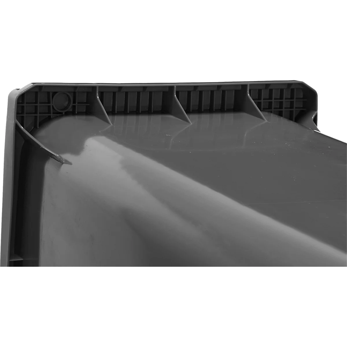 Primer plano de una esquina rectangular gris con un borde superior texturizado y superficies inclinadas.