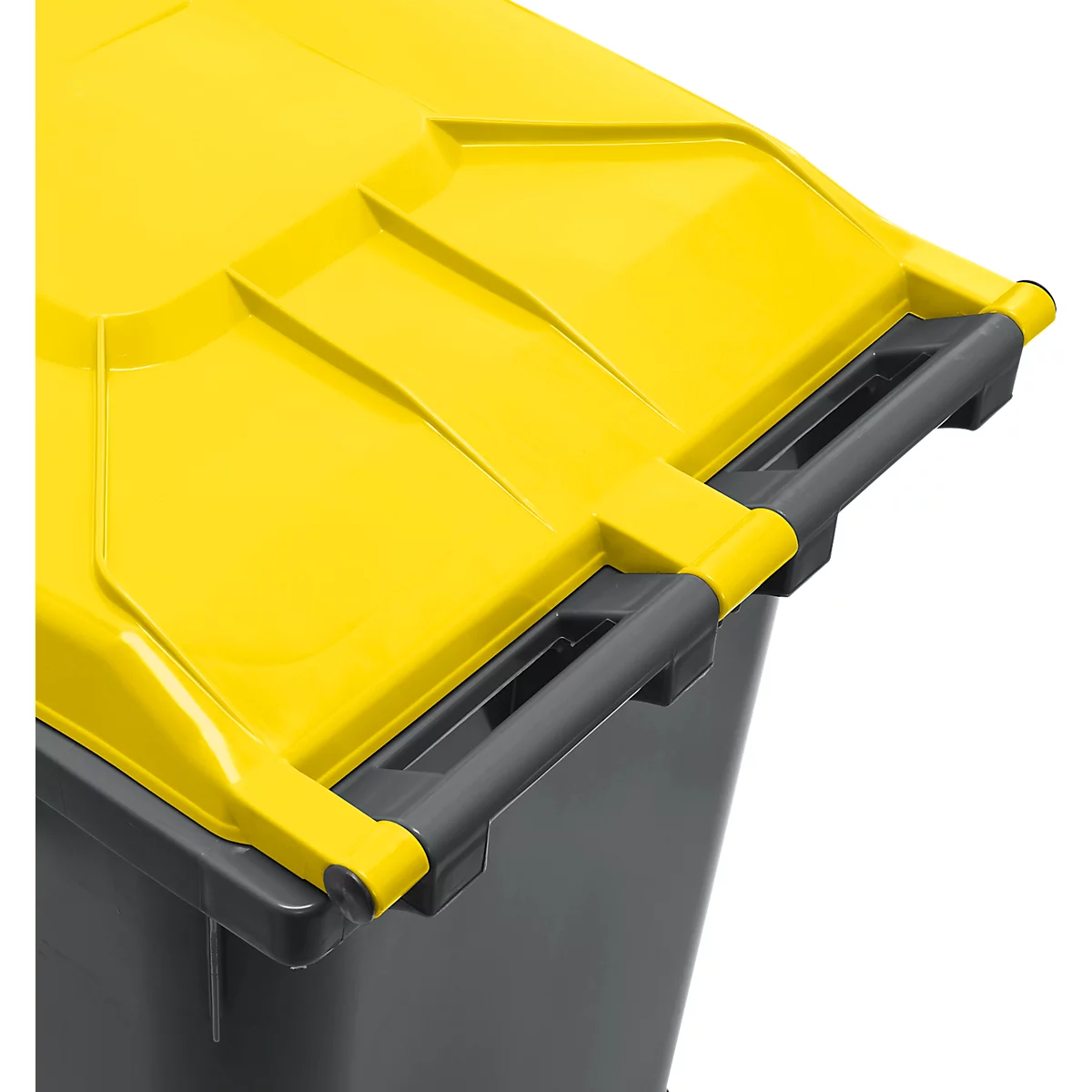 Primer plano de parte de un bote de basura amarillo con un asa oscura. La tapa del bote está abierta.