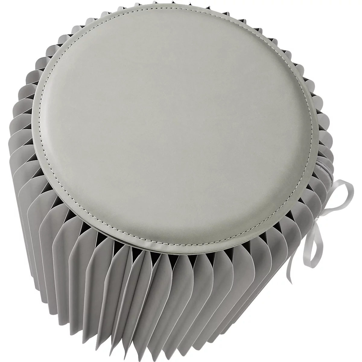 Lichtgrijze, ronde kruk met geplooide zijkanten en crèmekleurig deksel. Bovenop is een lint bevestigd om vast te binden.