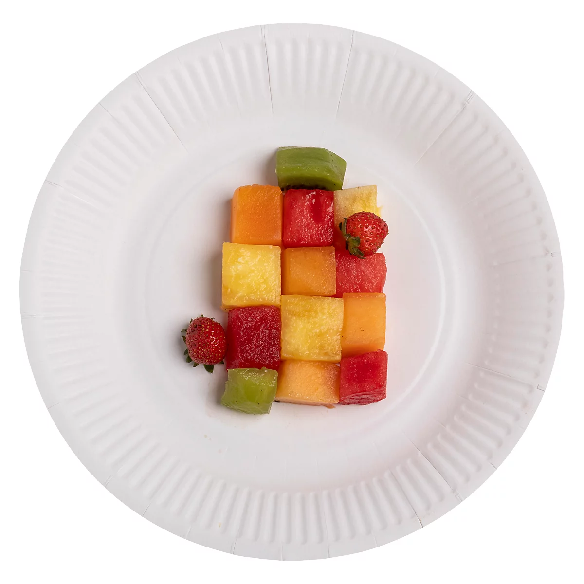Auf einem weißen Teller befinden sich Würfel aus verschiedenen Früchten, darunter Erdbeeren, Melone, Kiwi und Ananas.