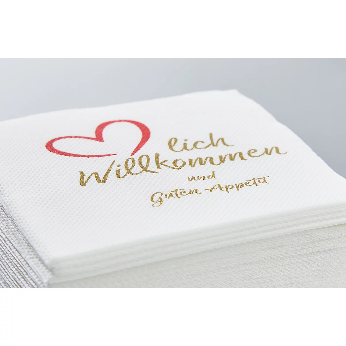 Serviettenstapel mit rotem Herz und Schriftzug "Willkommen und Guten Appetit".