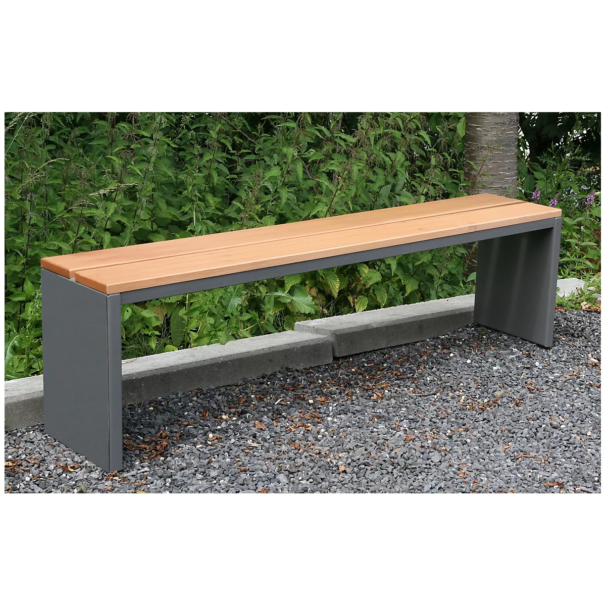 A modern garden bench with wooden seat and grey metal frame in front of a green backdrop.