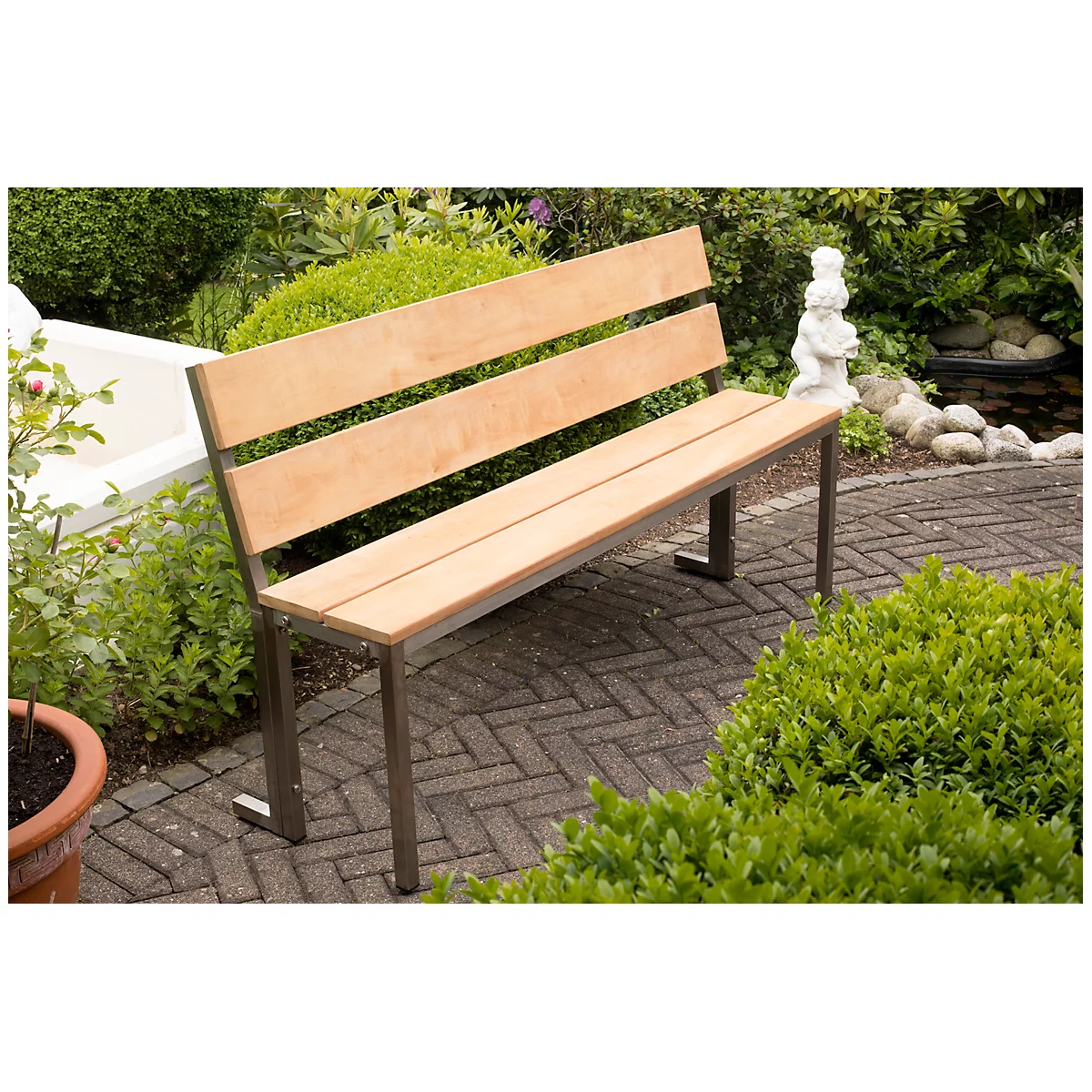 Houten bank in de tuin, met metalen frame. Achter de bank een vijver en groene struiken.