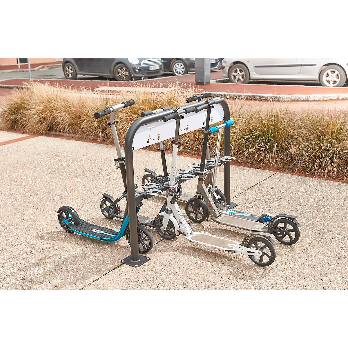 Several electric scooters stand at a stand outside.