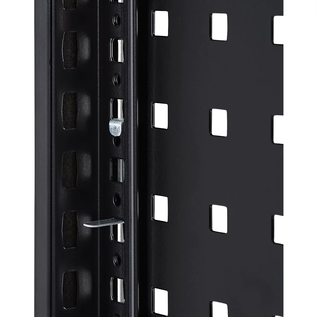 Gros plan sur une construction métallique noire avec des ouvertures rectangulaires et des raccords métalliques.