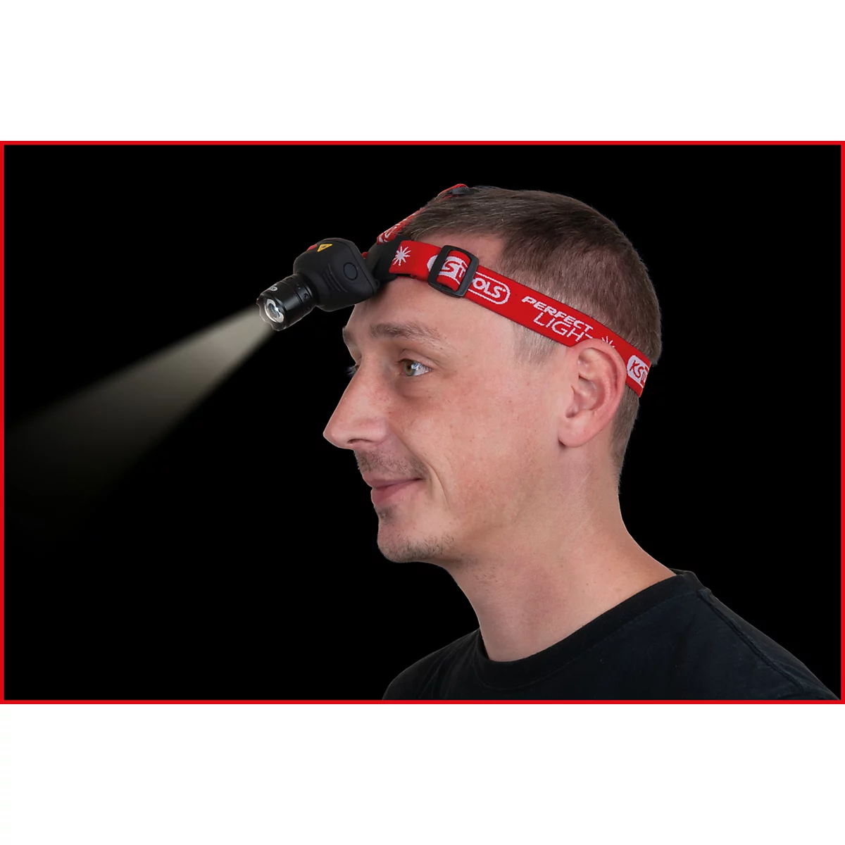 Mann mit Stirnlampe. Die Lampe leuchtet nach vorne, rotes Band mit Schriftzug.