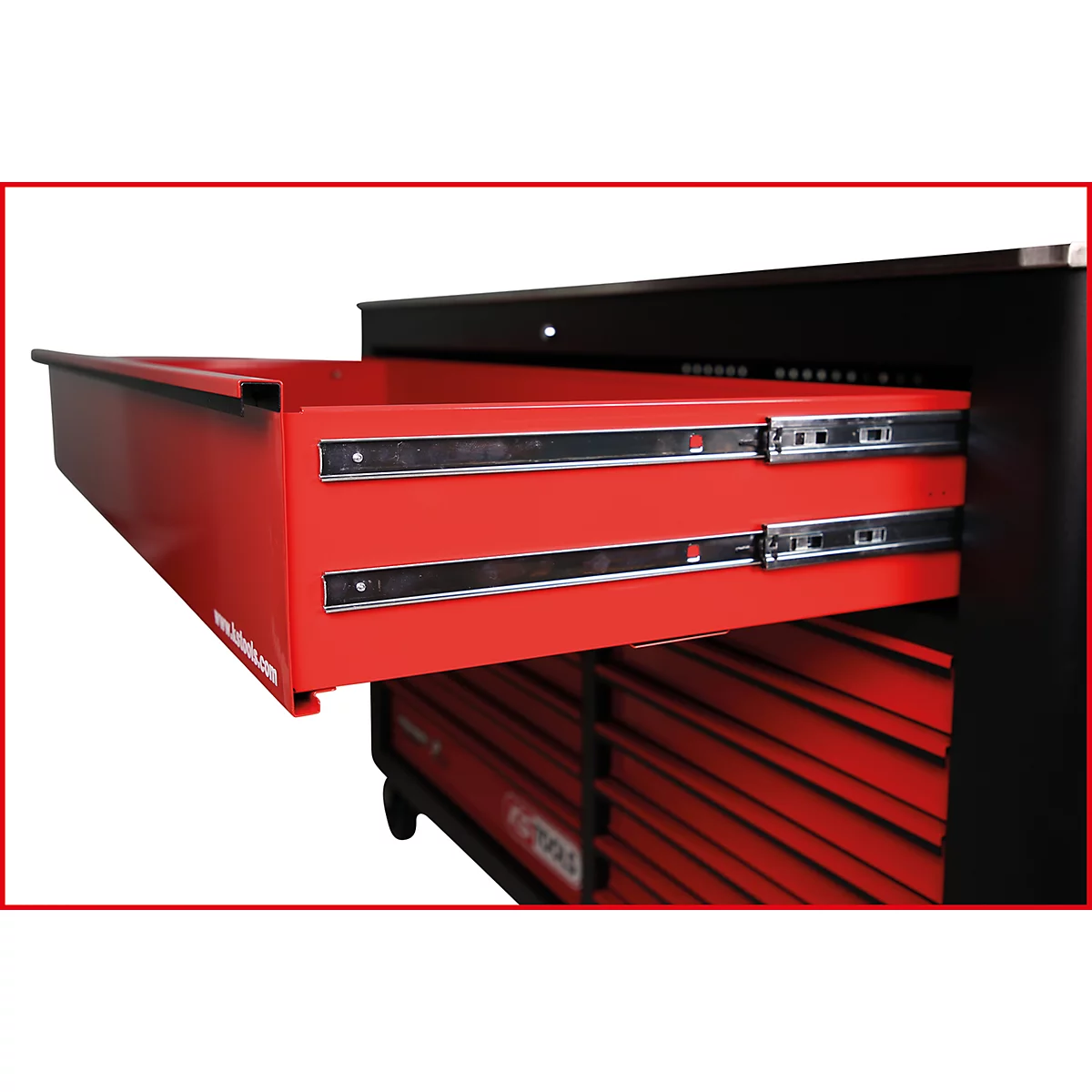 Offene rote Schublade einer Werkzeugkiste mit metallischen Schienen. Darunter weitere Schubladen und ein schwarzer Rahmen.