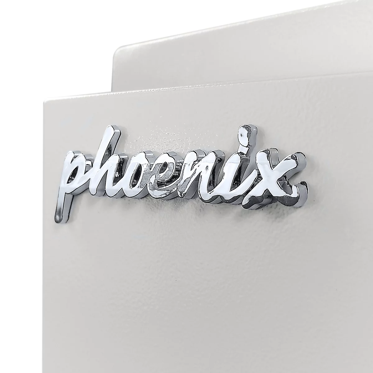 Nahaufnahme des verchromten Phoenix-Logos auf einer hellgrauen, metallischen Oberfläche.