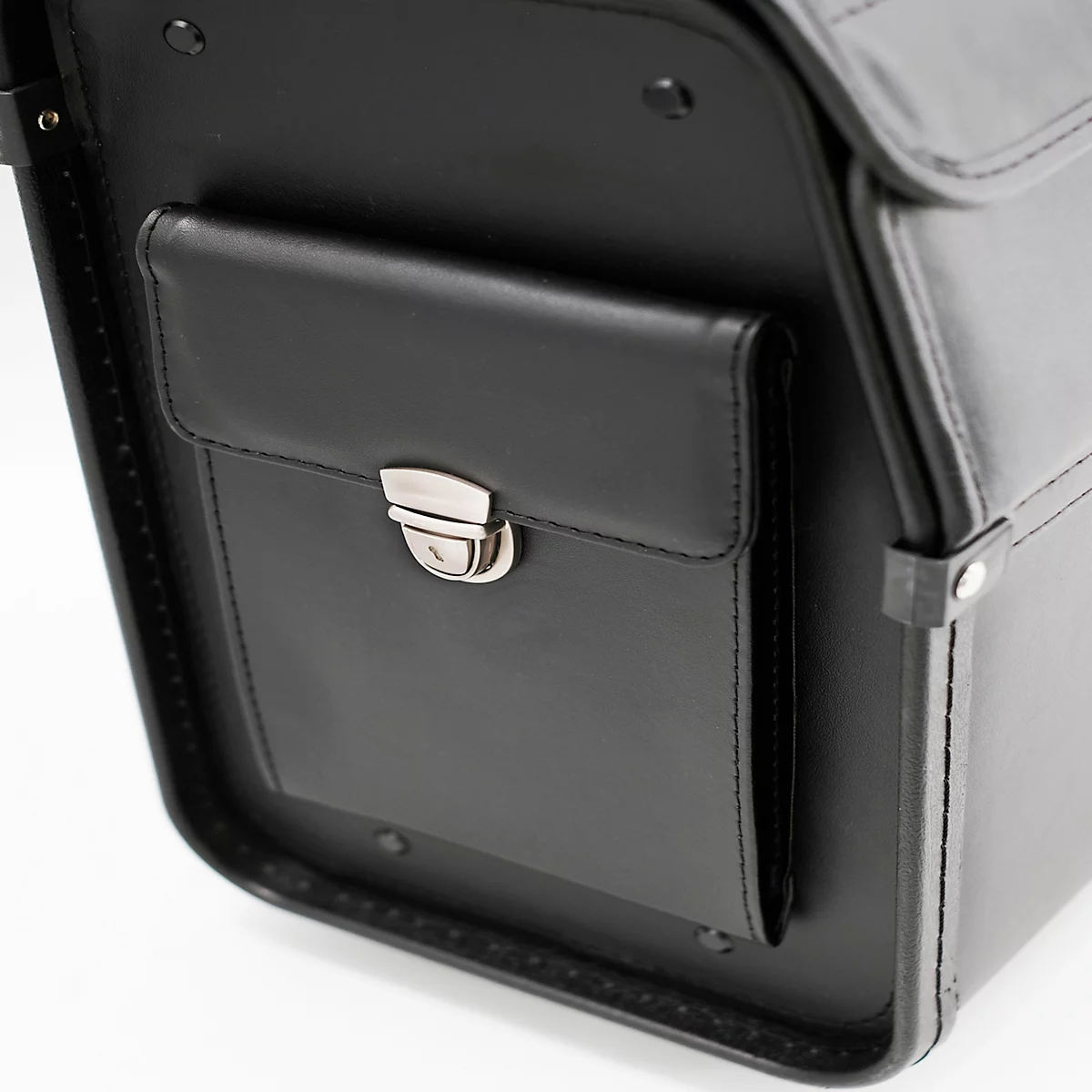 Detailopname van een zwarte leren tas met een kleinere voorzak en een zilveren sluiting.