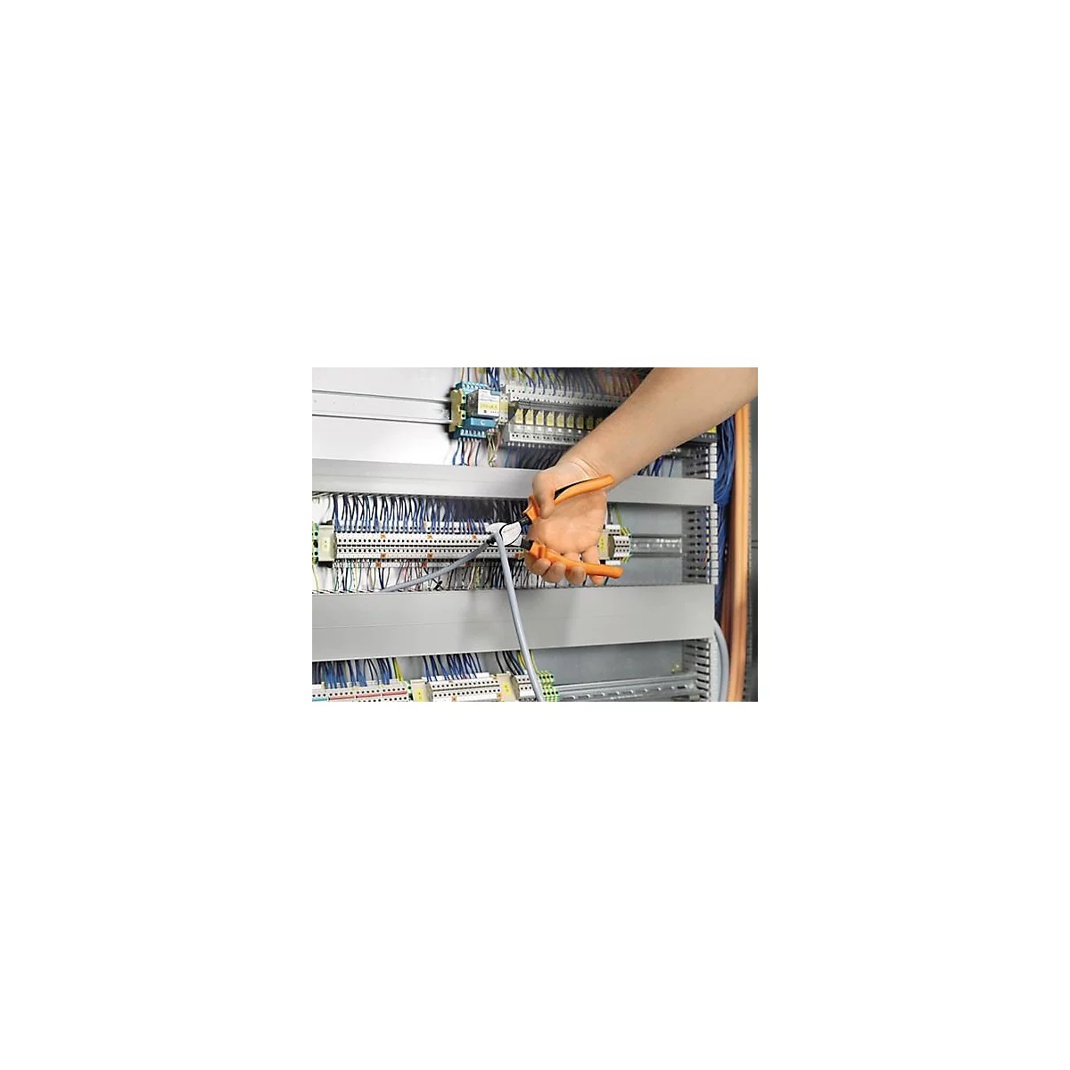 Main avec une pince orange fixant un câble gris à une installation électrique.