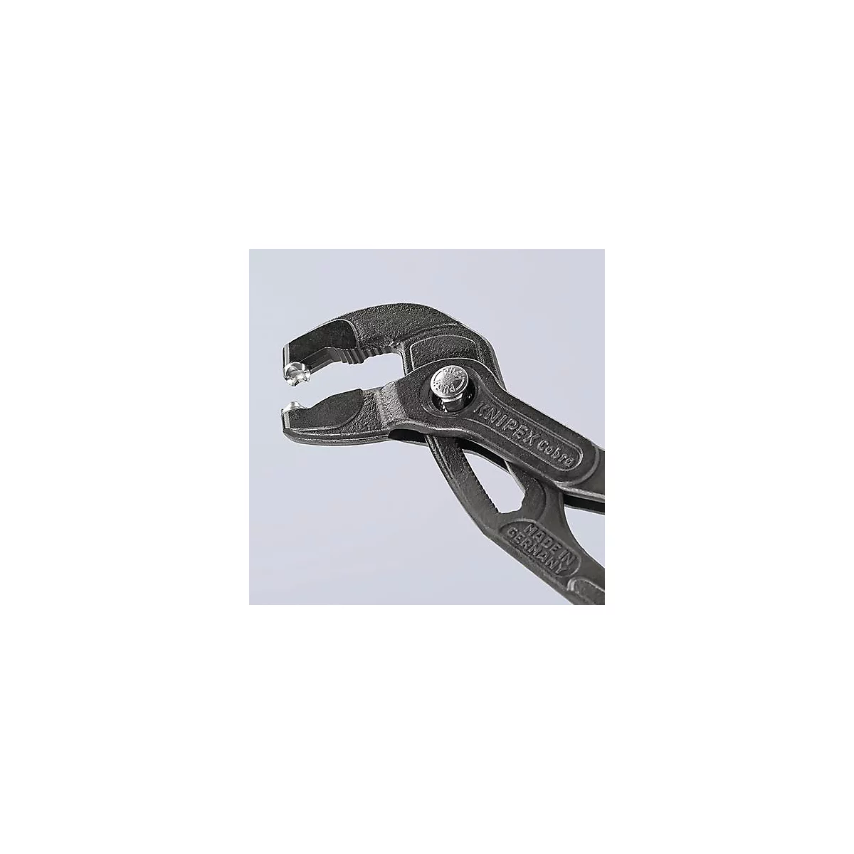 Gros plan d'une pince multiprise Knipex Cobra saisissant une pièce métallique. La poignée est marquée "MADE IN GERMANY".