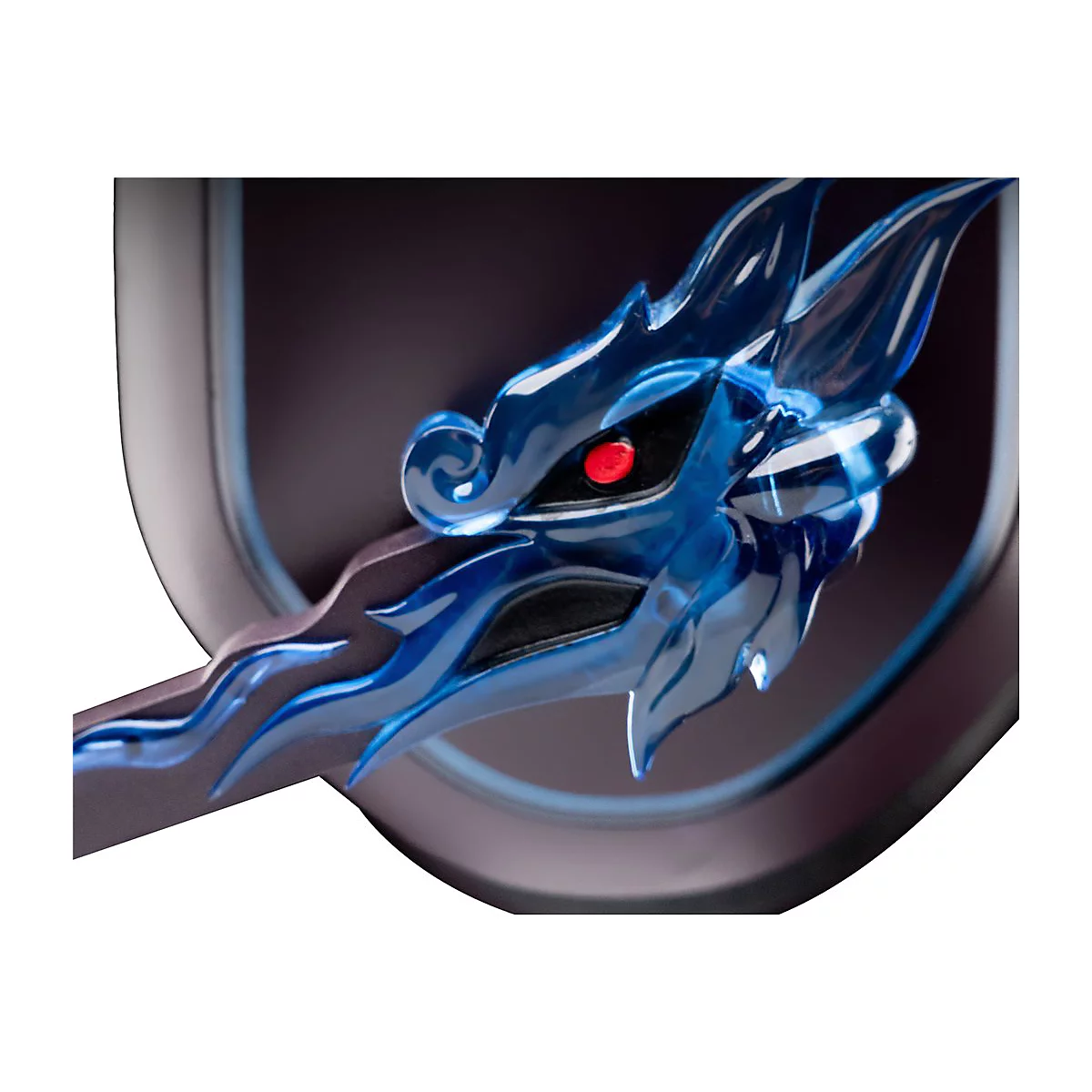 Gros plan d'une tête de dragon bleue avec des yeux rouges. La lumière se réfracte dans le matériau transparent.