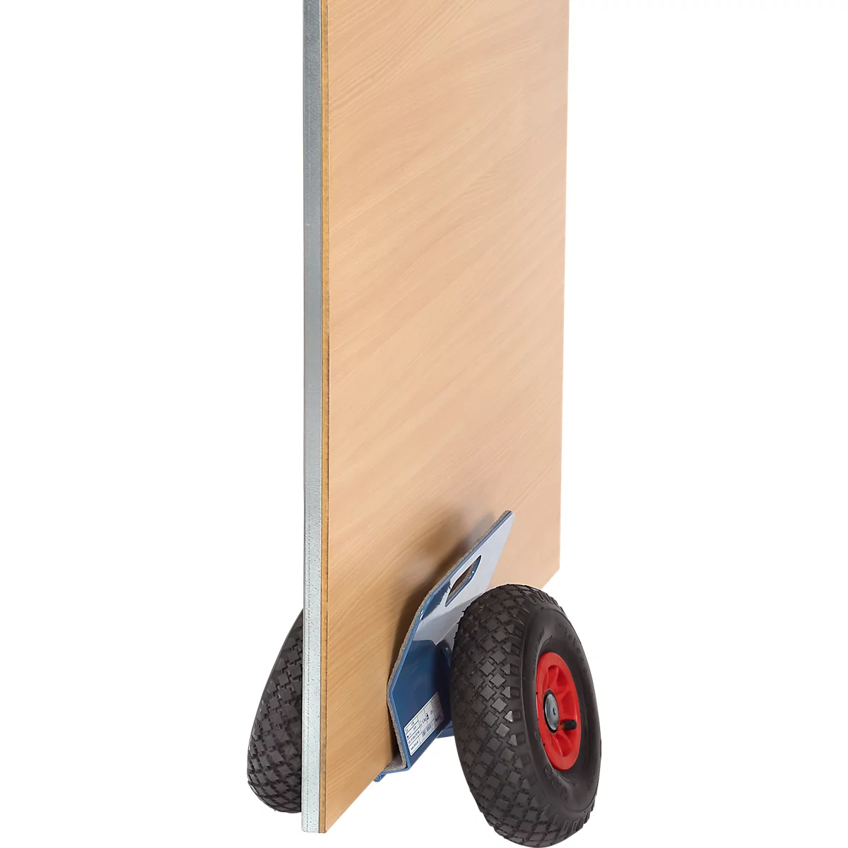 A wooden board on a hand truck. The wheels are black and red, the board is light brown.