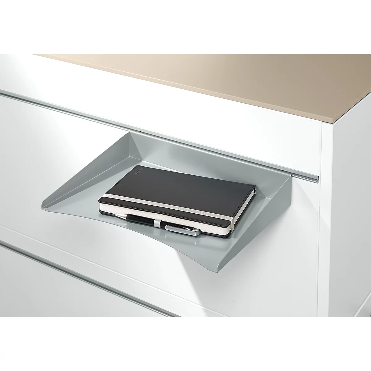 Étagère grise avec un carnet et un stylo. L'arrière-plan montre un tiroir blanc et une surface brune.