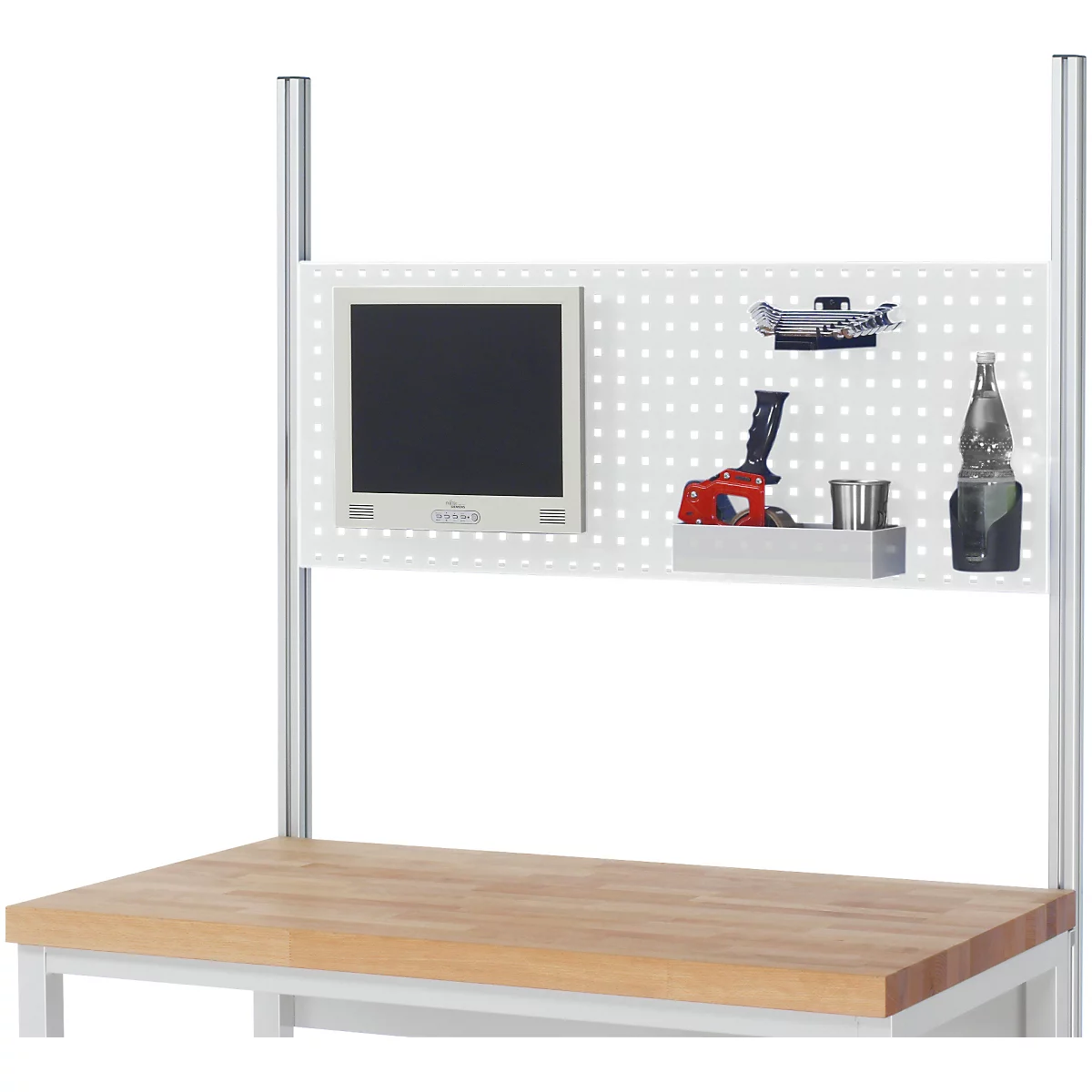 Établi avec panneau perforé, moniteur, outils et bouteille.