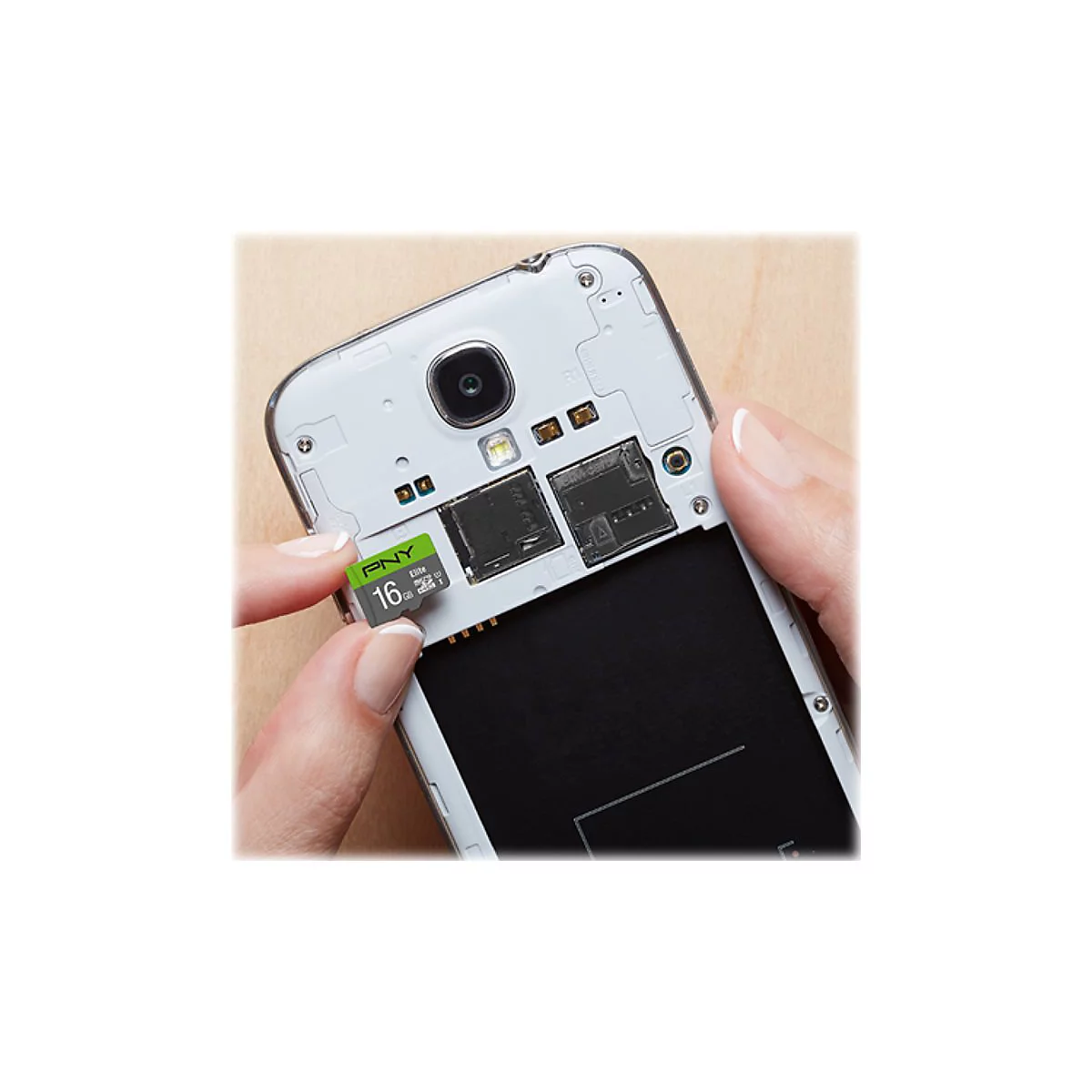 Eine Hand setzt eine grÃ¼ne PNY 16 GB Speicherkarte in ein geÃ¶ffnetes Smartphone ein.