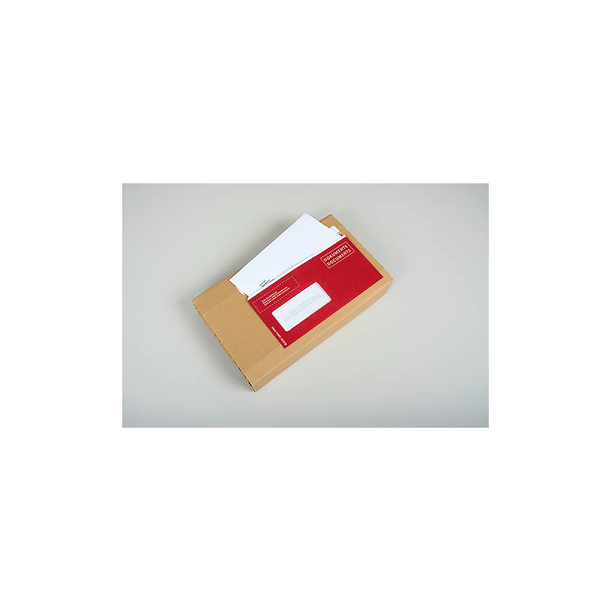 Un carton ouvert avec une enveloppe rouge et du papier blanc. L'enveloppe porte l'inscription "Documents".