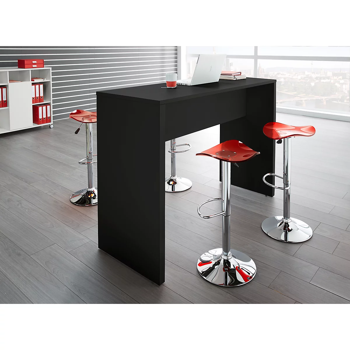 Black standing table with red bar stools, laptop and view from the window.