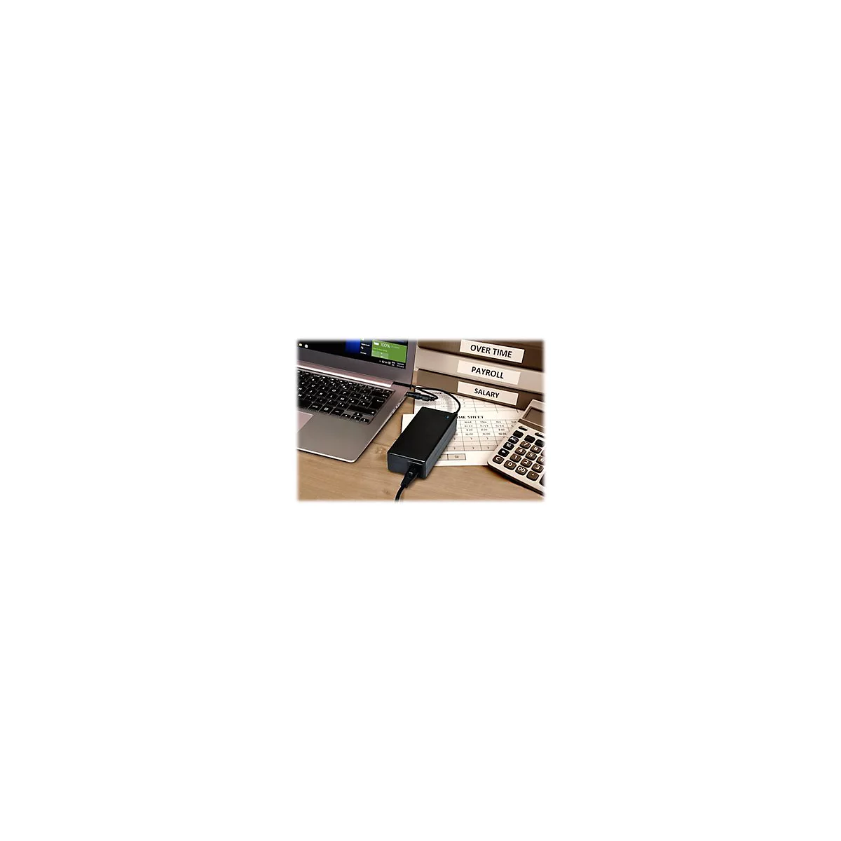 Ein schwarzes Laptop-LadegerÃ¤t liegt auf einem Schreibtisch, neben Laptop, Ordnern mit Beschriftung und einem Taschenrechner.