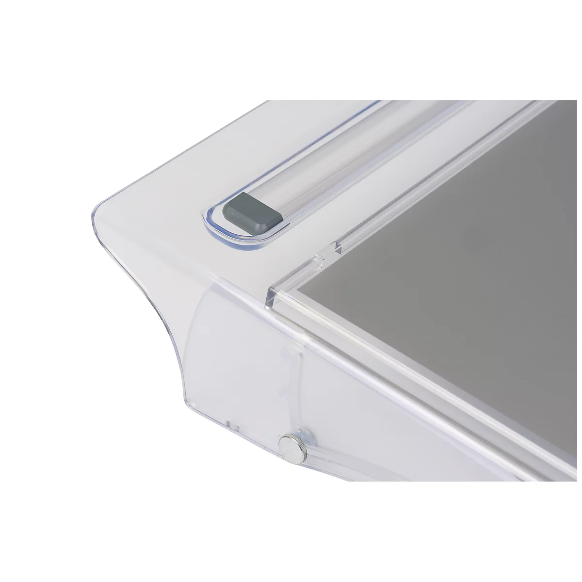 Gros plan d'un boîtier en plastique transparent avec un bouton gris et une surface grise.