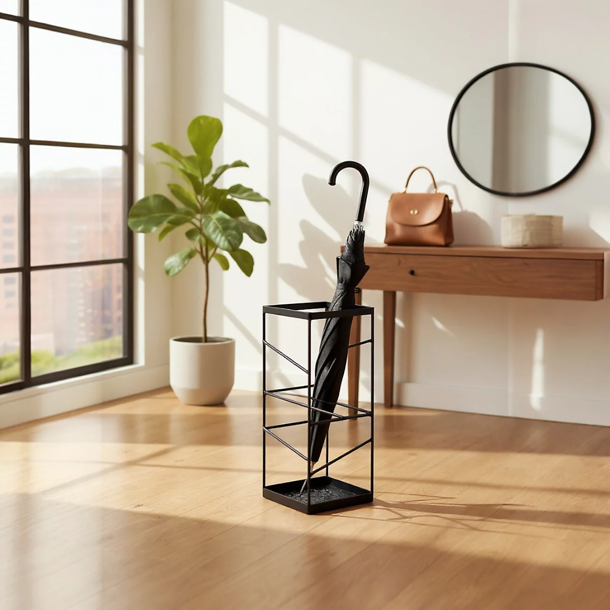 Parapluie noir dans un support métallique. Plancher en bois, fenêtre, plante en pot et miroir rond.