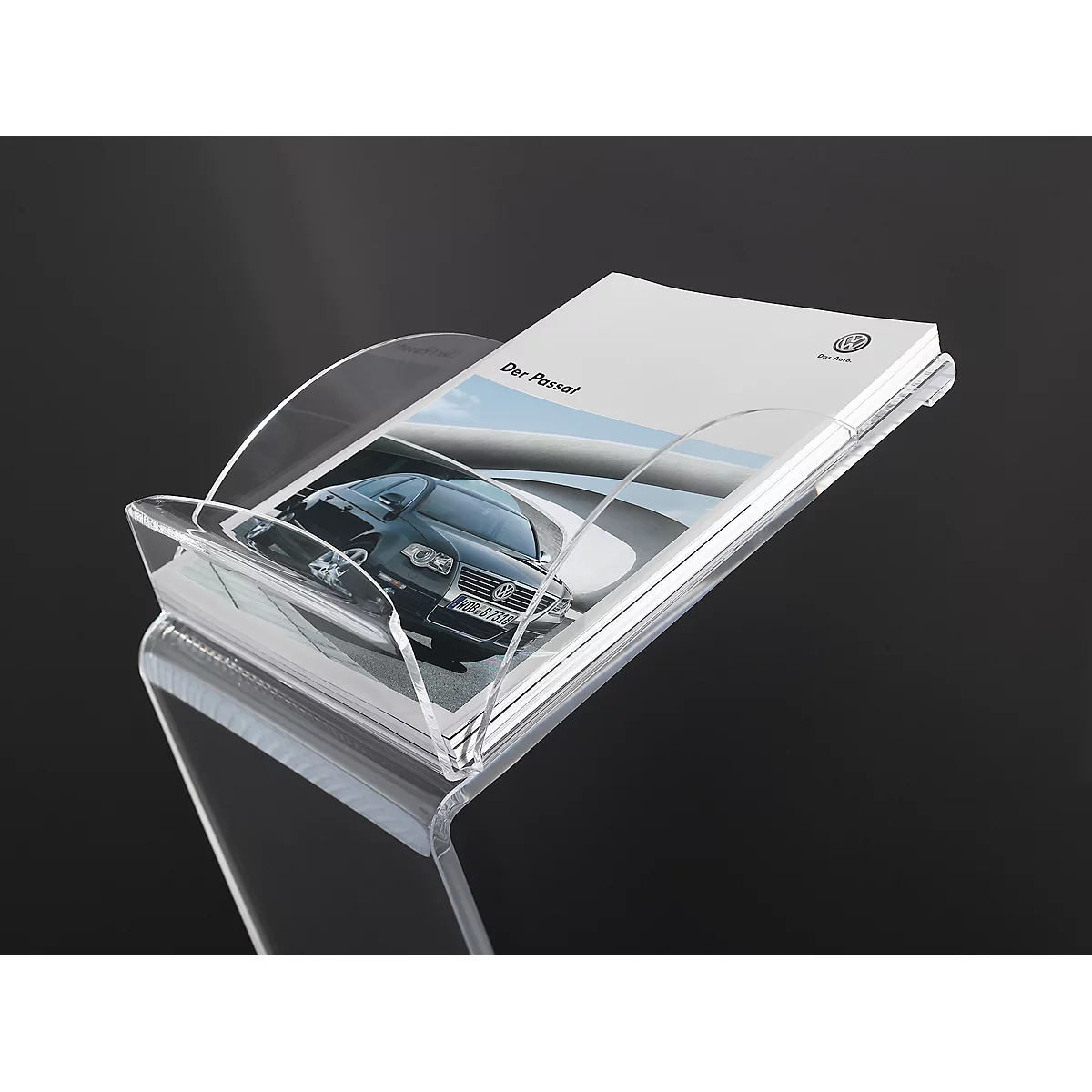 Porte-brochure transparent, rempli d'une brochure. Une voiture est représentée sur la brochure, au-dessus de laquelle est écrit "Der Passat".