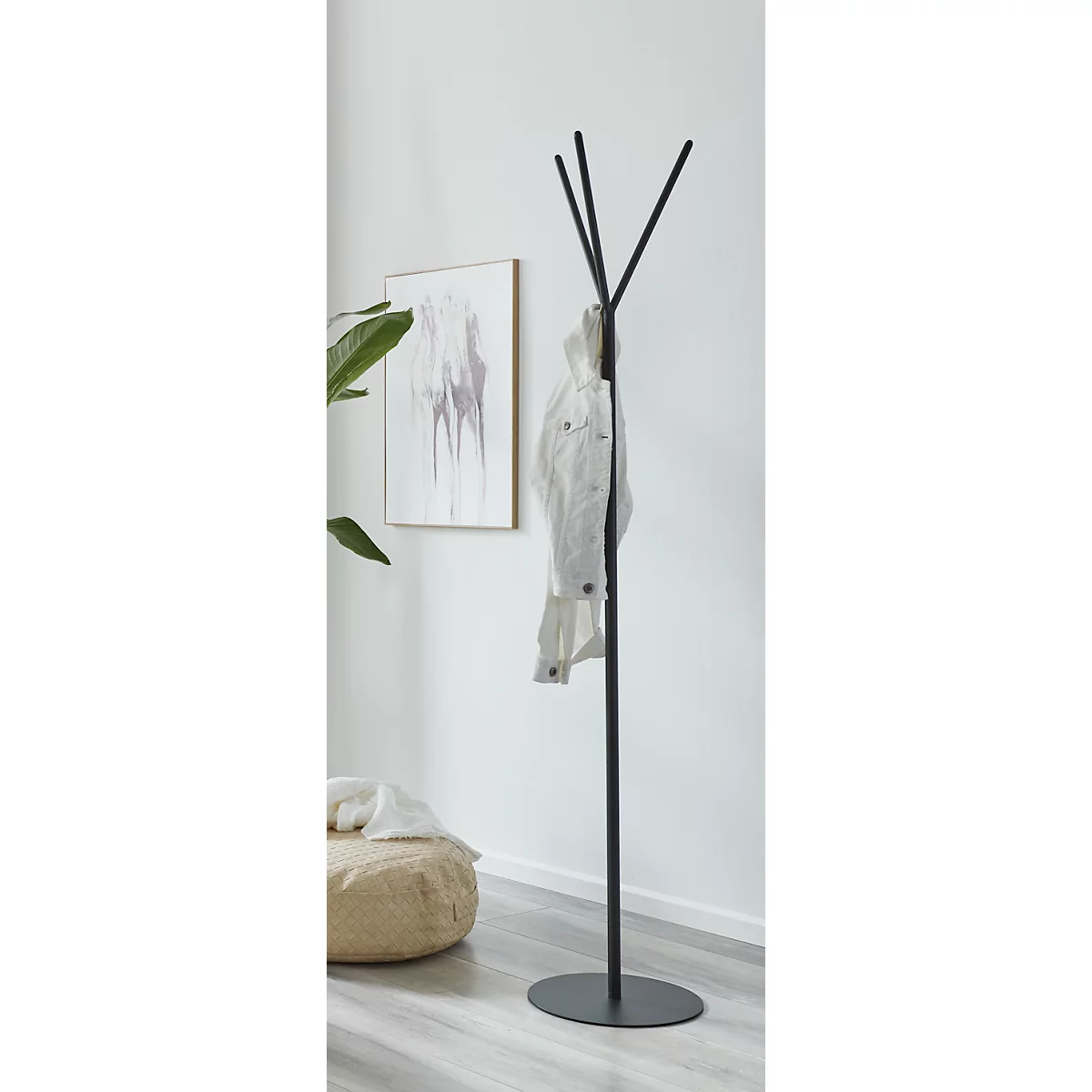 Porte-manteau noir avec veste blanche. Image et pouf en arrière-plan.
