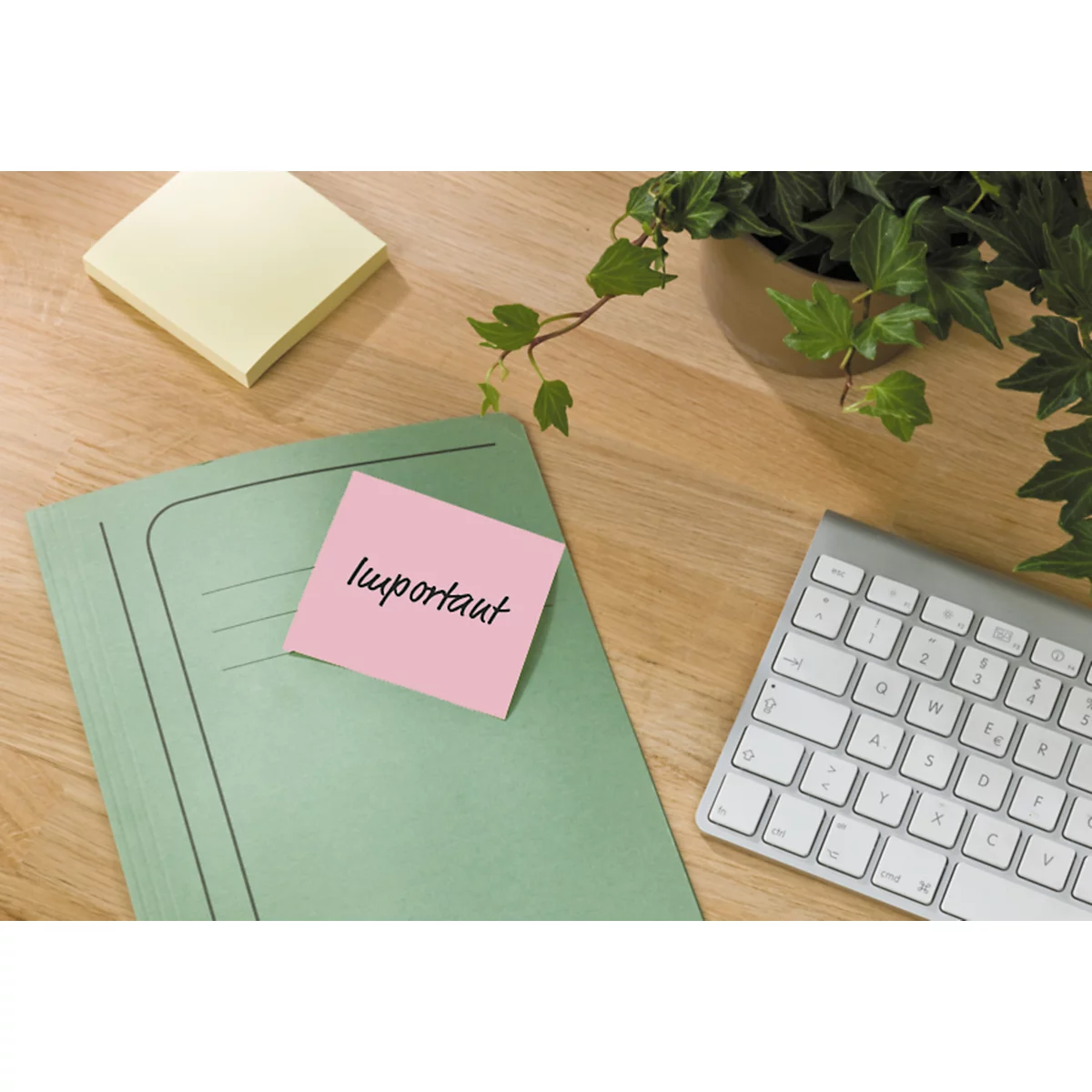Post-it-Notizblock, Karton mit Produktinformationen. Mehrfarbige Haftnotizen liegen daneben.