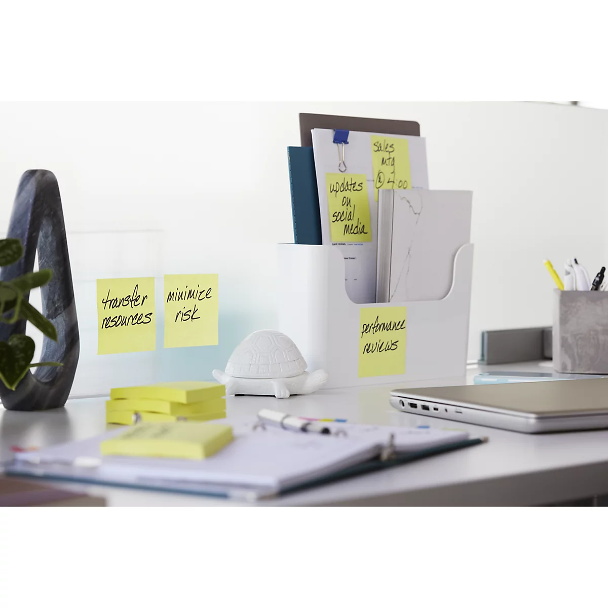 A desk with notes: "Transfer resources", "Minimize risk", "Updates on social media".