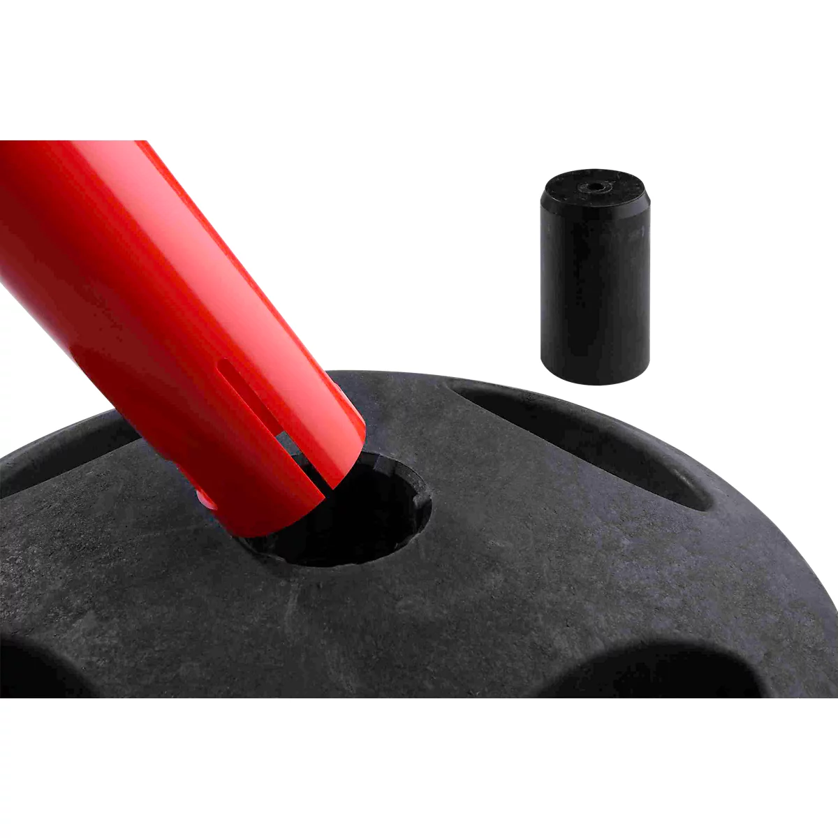 Gros plan sur une extrémité de poteau rouge insérée dans une base noire, avec un capuchon noir à côté.