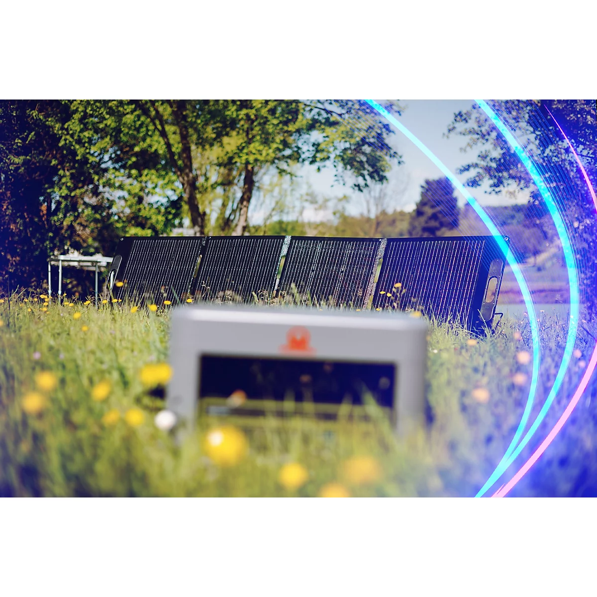 Ein faltbares Solarmodul steht auf einer blühenden Wiese vor einer Powerstation im Vordergrund.