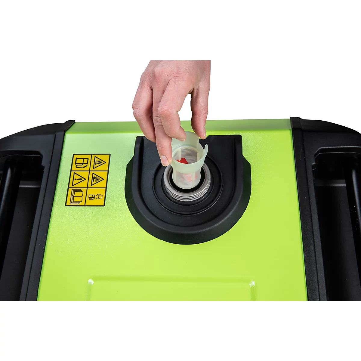 Hand setzt einen hellen Kraftstofffilter in die Öffnung eines grünen Stromerzeugers ein.