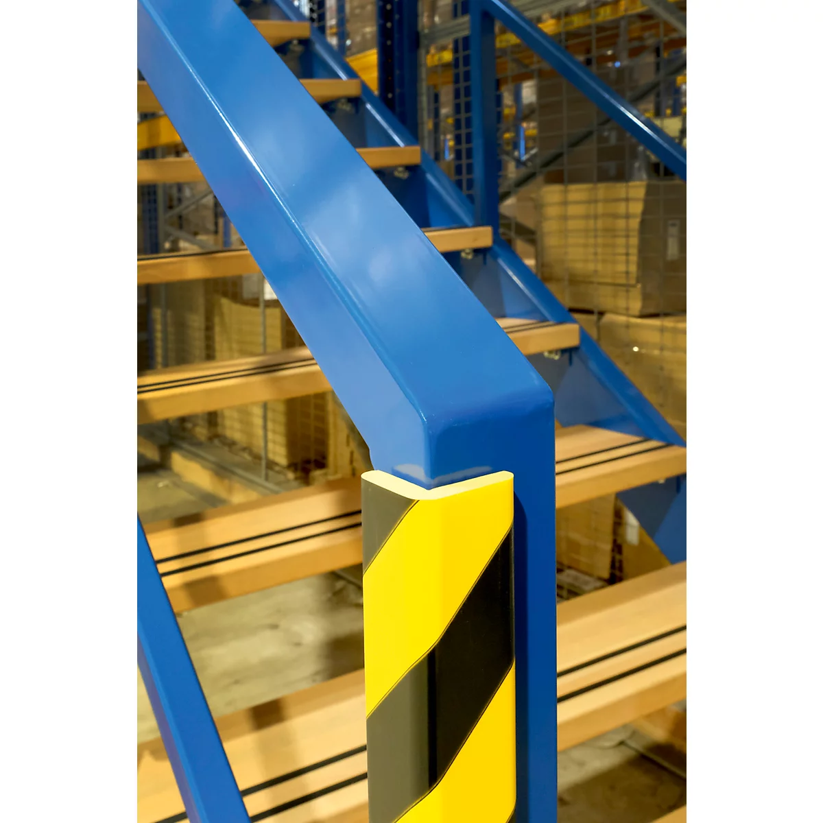 Protection d'angle jaune et noir, en forme de L. Bandes jaunes et noires alternées.