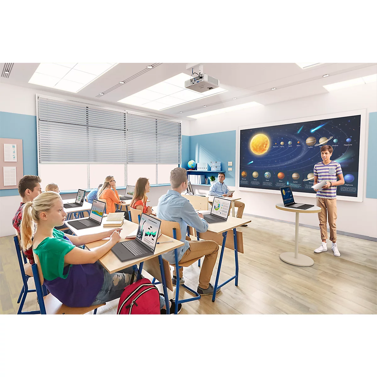 Élèves en classe; un garçon présente au tableau blanc; ordinateur portable sur la table.